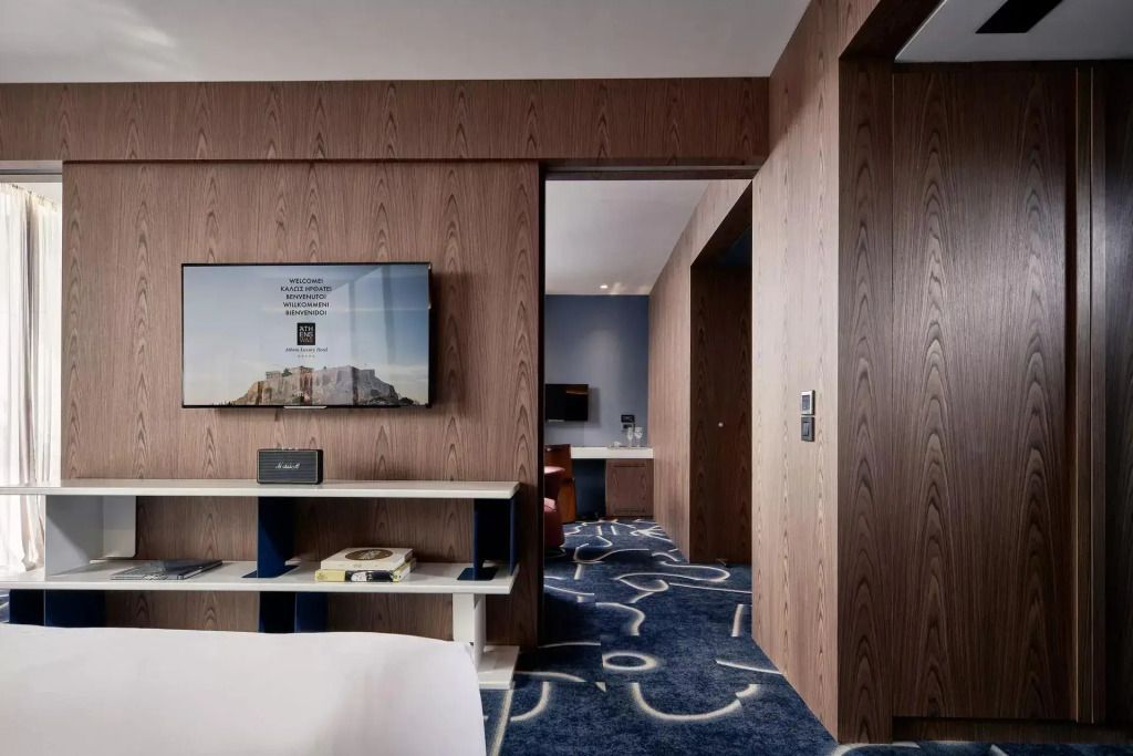 Zimmeransicht mit Holzwänden, TV und Übergang zum anderen Bereich der Suite