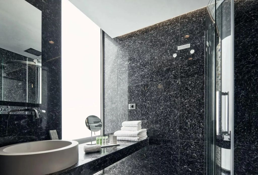 Modernes Bad im AthensWas Design Hotel mit dunklen Fliesen und Waschtisch