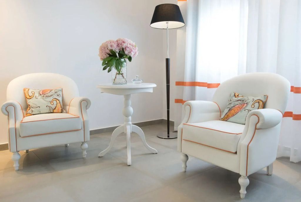 Helles Wohnzimmer mit eleganten Sesseln und Blumenarrangement