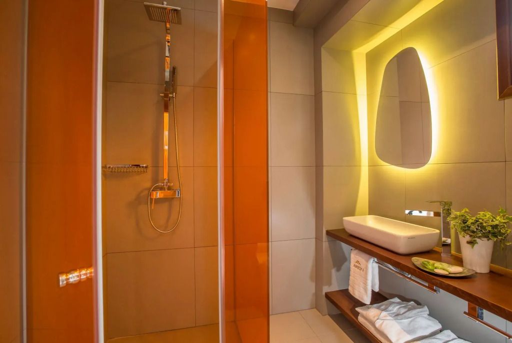 Dusche mit modernen Armaturen und stilvollem Spiegel im Badezimmer
