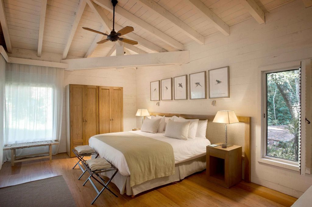 Geräumiges Schlafzimmer mit Holzbalkendecke und großem Bett