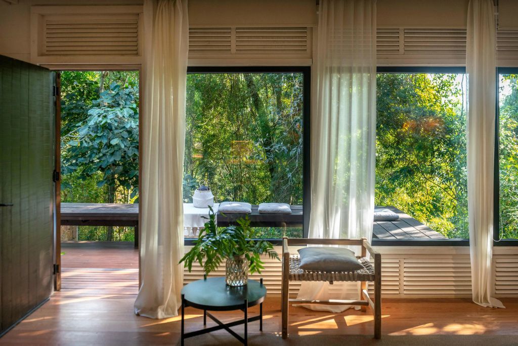Geräumige Fenster mit Blick auf üppigen grünen Garten durch transparente Vorhänge