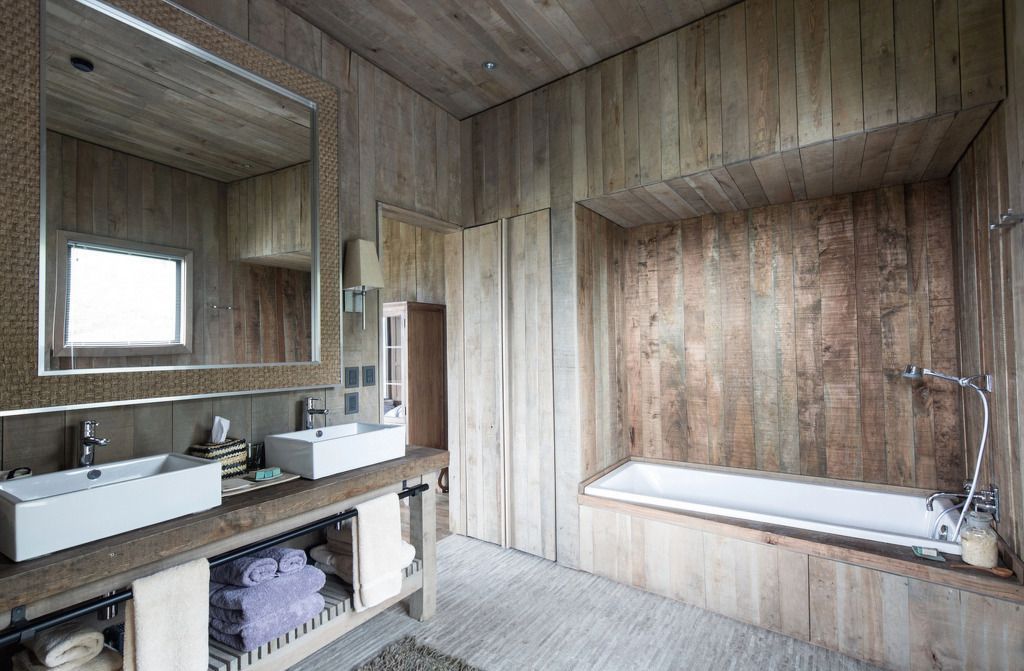 Rustikales Badezimmerdesign mit Holzverkleidung und freistehender Badewanne