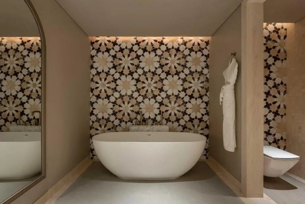 Badezimmer in Deluxe Familie Suite mit freistehender Badewanne und stilvoller Fliesenwand