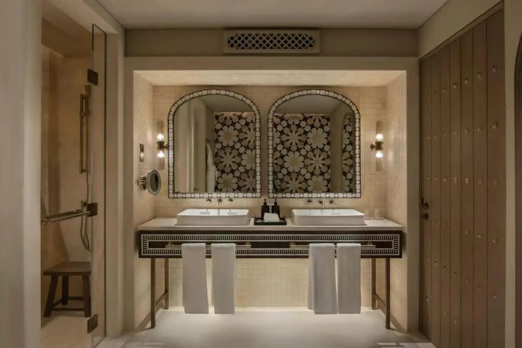 Elegantes Badezimmer mit zwei Waschbecken und mosaikverzierten Spiegeln