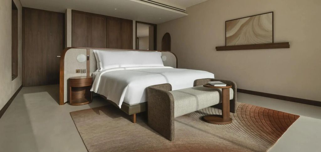 Elegantes Schlafzimmer der Doppel Desert Pool Villa mit Doppelbett und moderner Einrichtung.