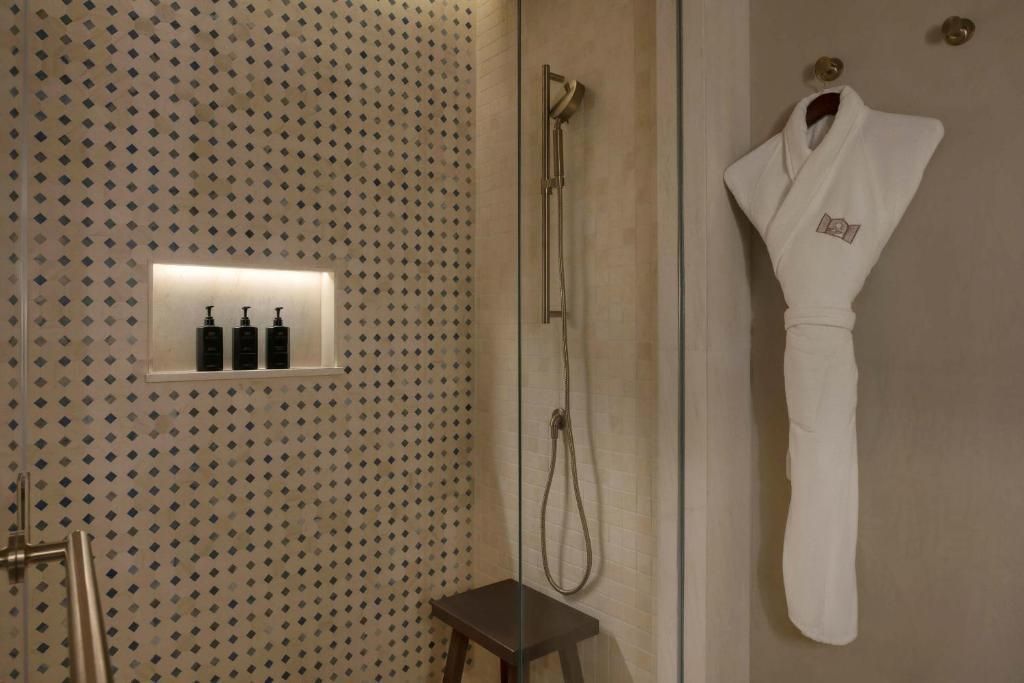 Stilvolles Badezimmer mit Dusche und Bademantel im Hotel Bab Al Shams