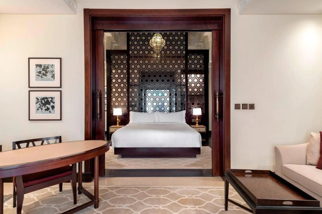Holzverzierte Trennwand mit Blick auf gemütliches Bett, elegant dekorierte Villa