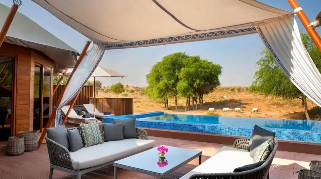 Privater Poolbereich mit Blick auf Wüstenlandschaft und elegantem Outdoor-Sofa