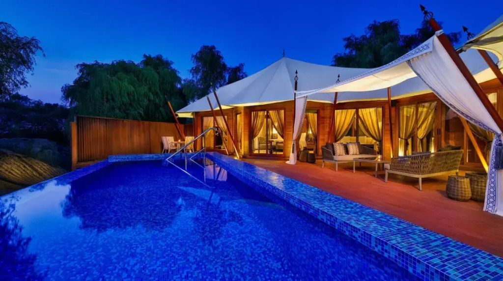 Beleuchtete Poolterrasse vor der Villa bei Nacht mit stilvollem Design