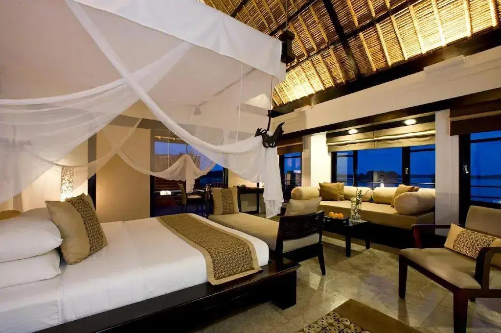 Helles Schlafzimmer mit Himmelbett und gemütlicher Sitzecke bei Nacht