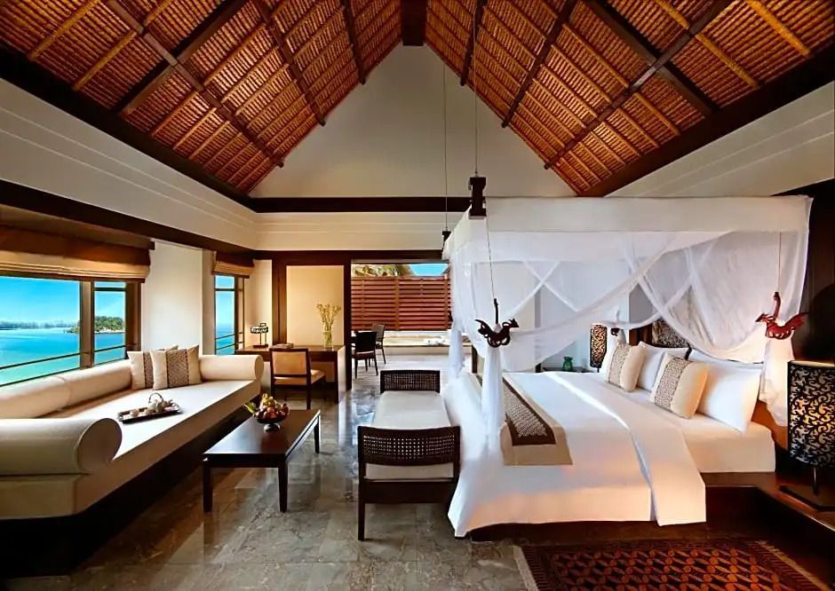 Rainforest Villa mit elegantem Himmelbett, Meerblick und gemütlicher Sitzecke.