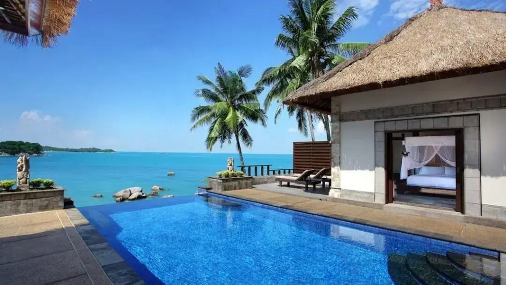 Infinity Pool mit Palmen und weitem Blick auf das türkisblaue Meer