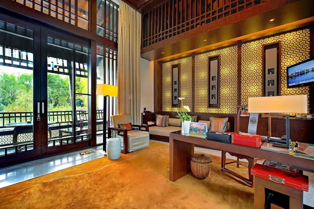 Gemütliches Wohnzimmer einer Villa mit eleganter asiatischer Einrichtung und warmen Farben.