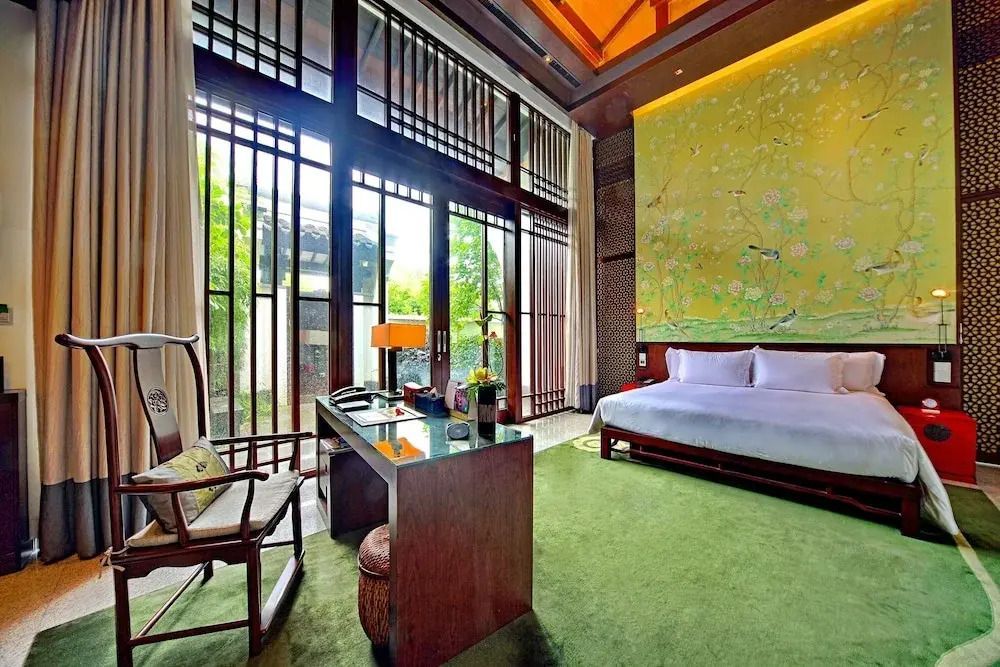 Großzügiges Schlafzimmer mit modernem asiatischen Dekor und großen Fenstern.