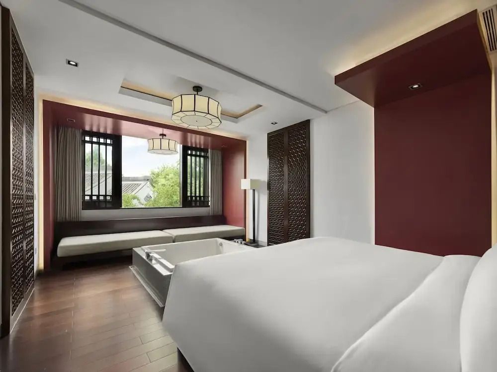 Modernes Schlafzimmer mit großem Fenster und komfortablem Doppelbett