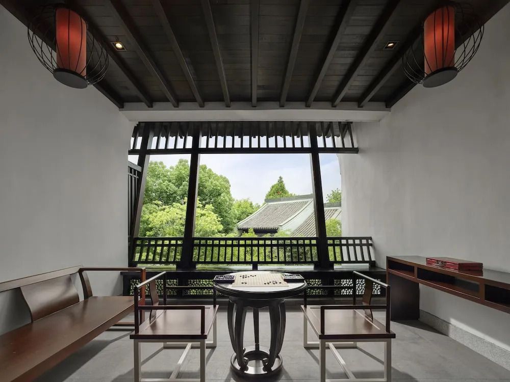 Traditionell eingerichteter Raum mit großem Fenster und Gartenblick
