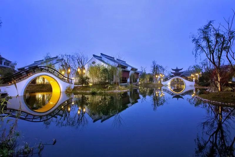 Traditionelle Architektur des Banyan Tree Hangzhou bei Abenddämmerung am Wasser