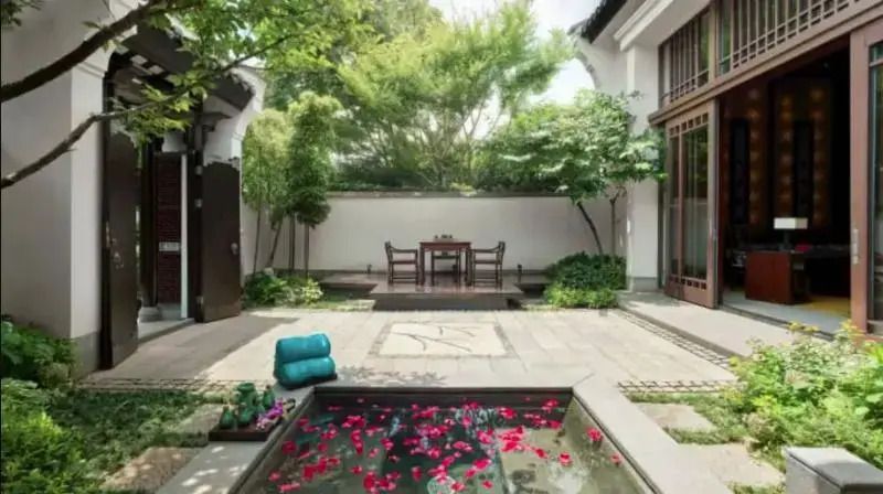 Privater Gartenbereich der Villa mit Wasserbecken und blühenden Blumen