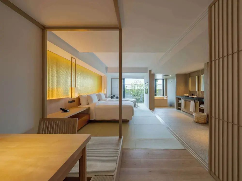 Offenes Zimmerdesign mit Schlafbereich und Sitzgelegenheit im Banyan Tree Kyoto.
