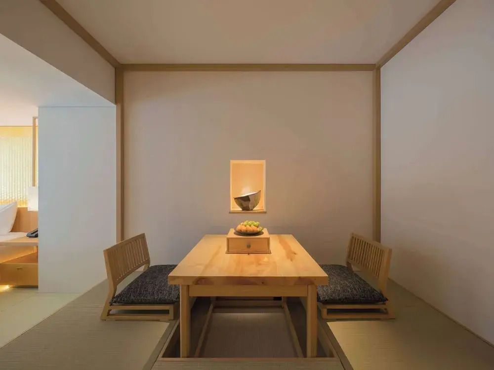 Traditioneller japanischer Teeraum mit niedrigem Tisch und Sitzkissen.