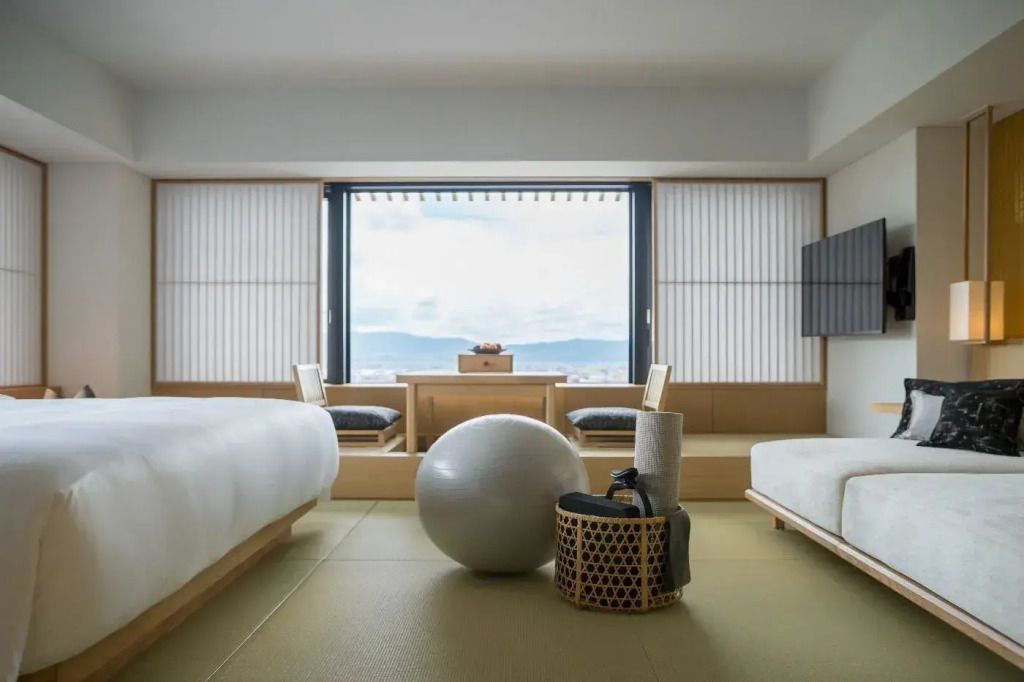 Zimmer mit Sitzbereich und großem Fenster mit Blick auf die Berge.