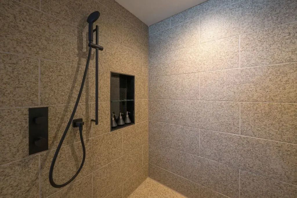 Moderne Duschkabine mit dunklem Armaturen in einem Badezimmer.