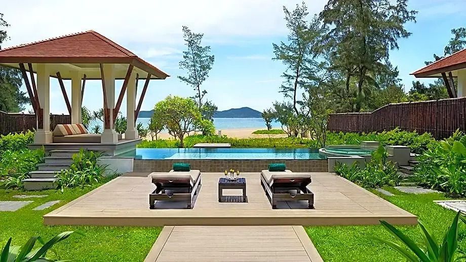 Sonnendeck mit Pool und Meerblick in tropischer Umgebung