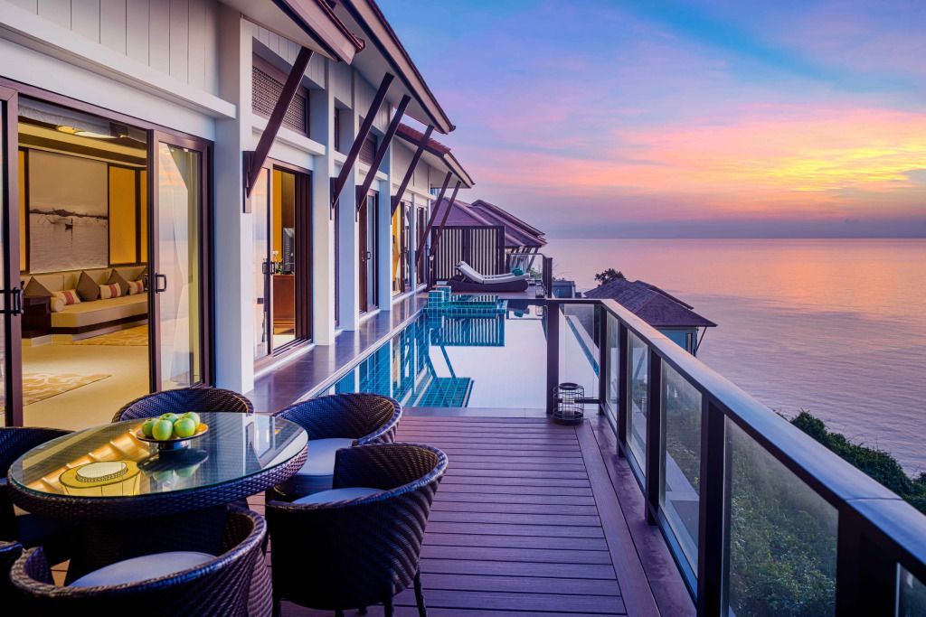 Terrasse mit Sitzbereich und Infinity-Pool bei Sonnenuntergang