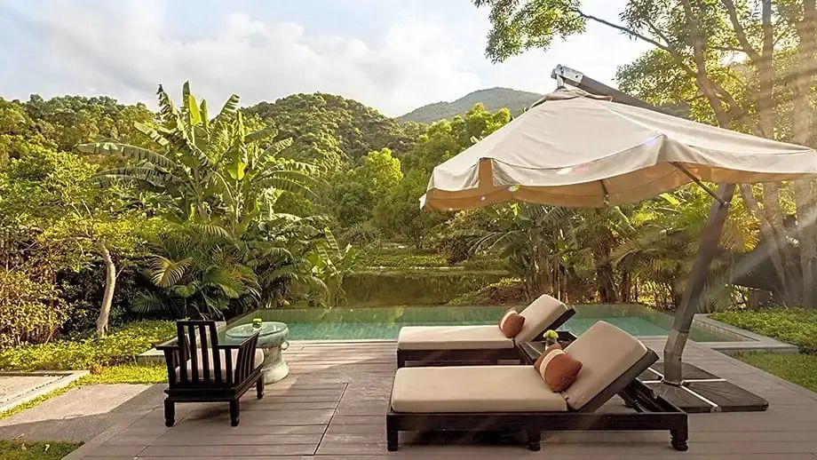 Exklusive Villa-Terrasse mit Sonnenliegen und Blick auf grüne Landschaft im Banyan Tree Lang Co