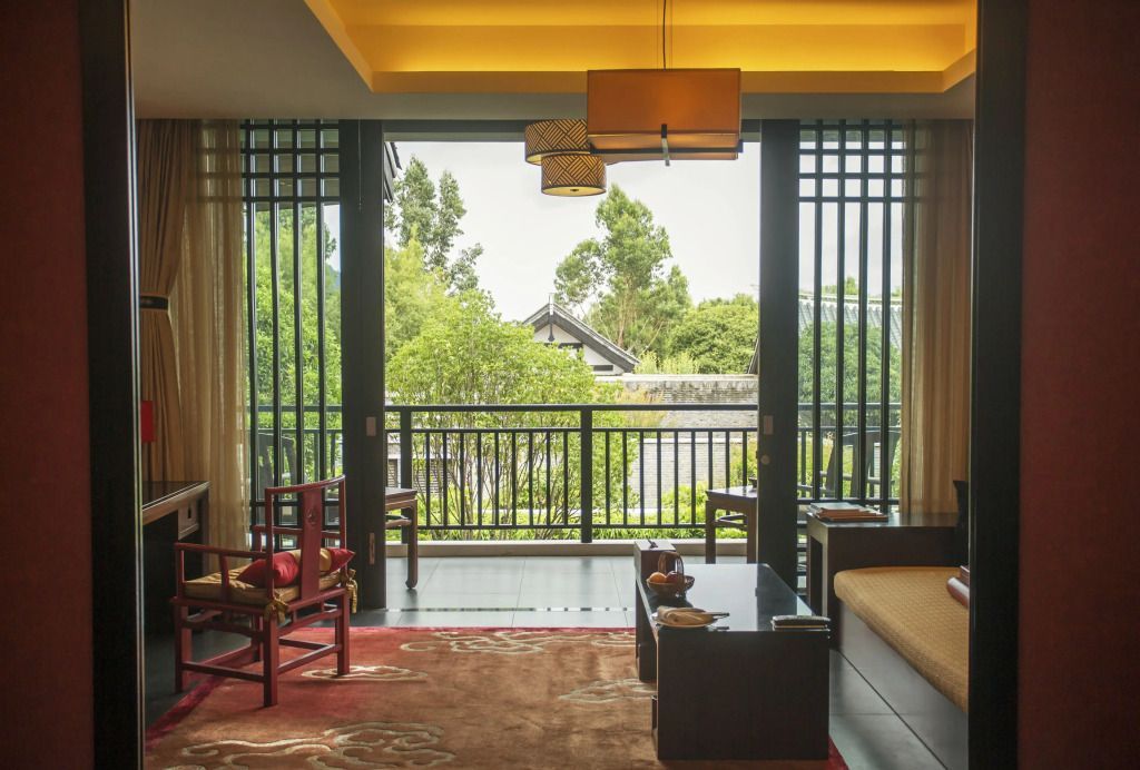 Elegante Suite mit Blick auf einen grünen Innenhof vom Balkon