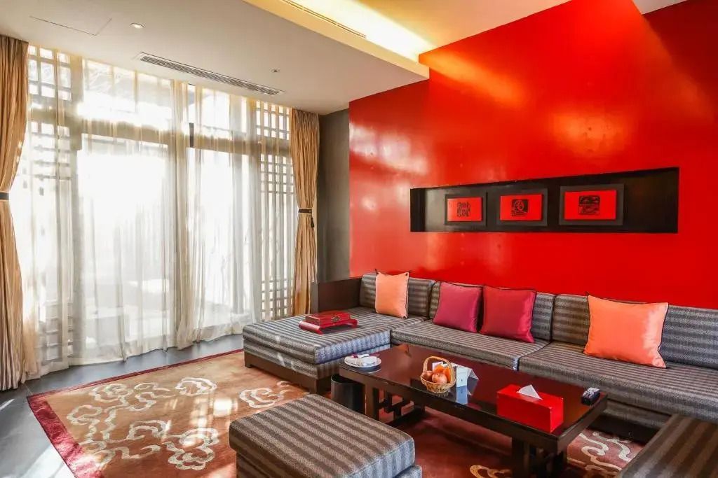 Gemütlicher Wohnbereich mit moderner Einrichtung und roten Akzenten im Banyan Tree Lijiang