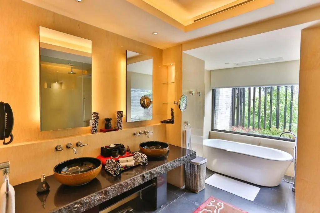 Luxuriöses Badezimmer mit Doppelwaschbecken und freistehender Badewanne im Banyan Tree Lijiang