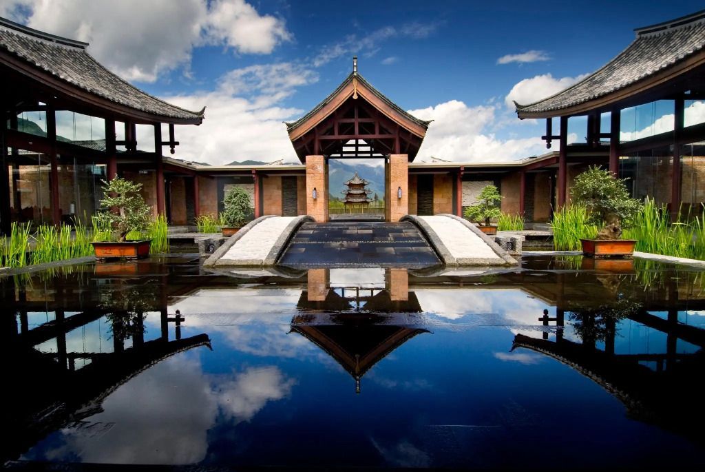 Traditionelle chinesische Architektur mit Wasserspiegelung und Pagode im Hintergrund