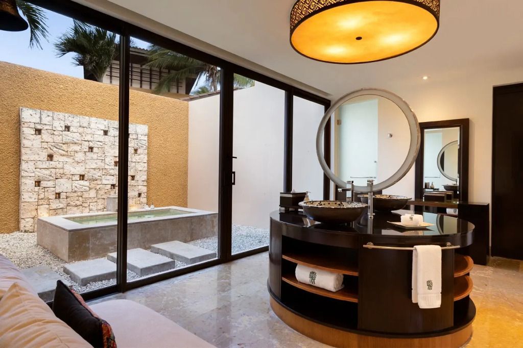 Luxuriöses Badezimmer mit großer Spiegelwand und Blick auf privaten Außenbereich
