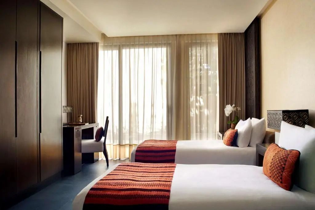 Elegantes Schlafzimmer mit zwei Betten, großen Fenstern und sanfter Beleuchtung