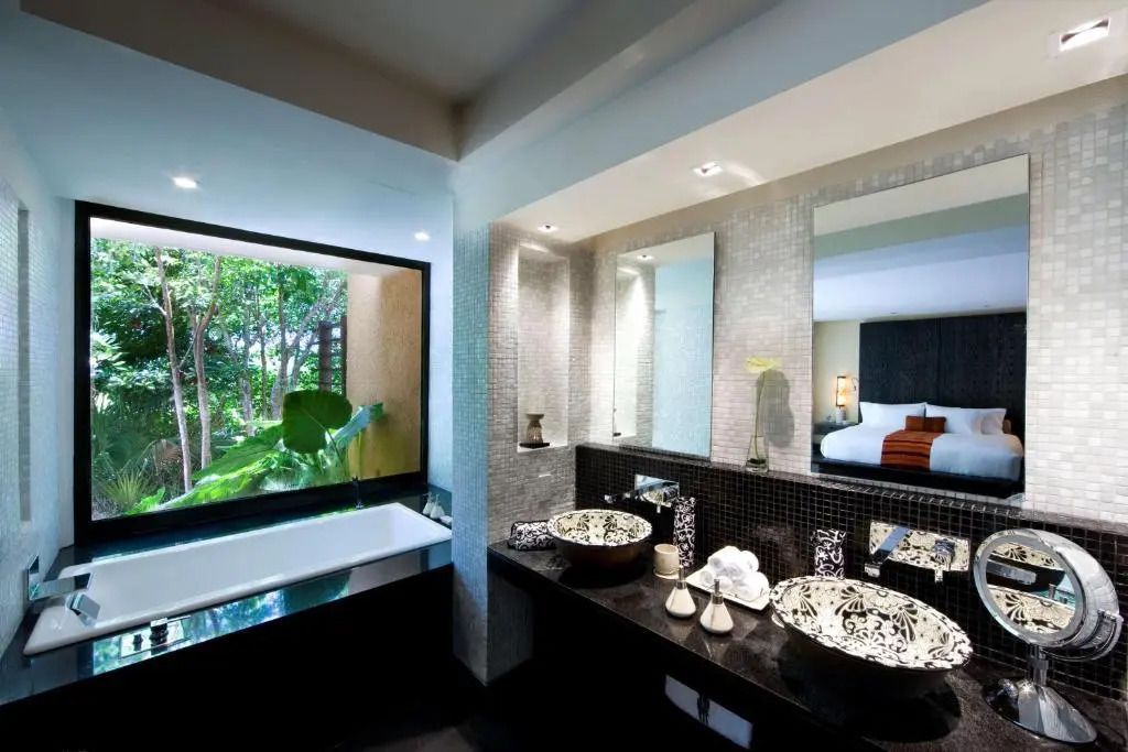 Luxuriöses Badezimmer mit großer Badewanne und Blick in die Natur