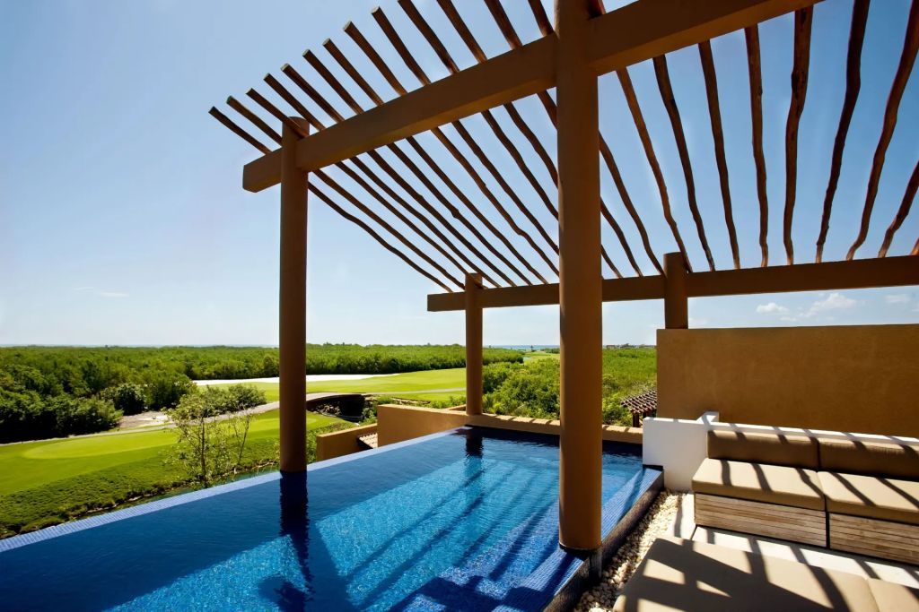 Infinity-Pool mit atemberaubendem Blick auf die Natur und Holzpergola.
