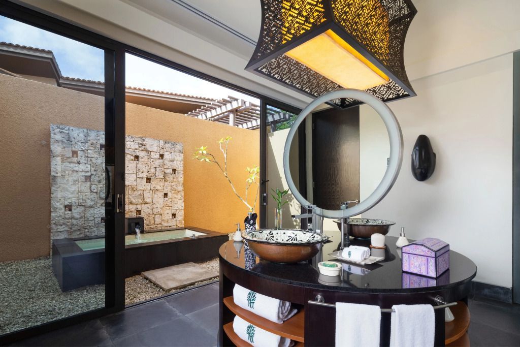 Luxuriöses Badezimmer mit großer Spiegelwand und Blick in den Garten