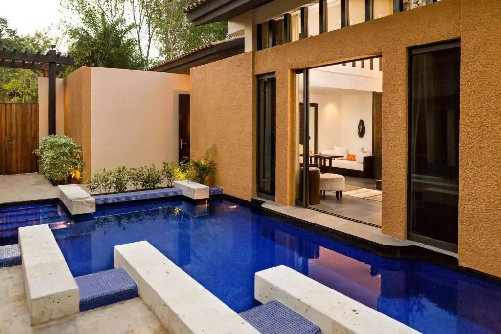 Moderner Poolbereich verbunden mit der Villa und umgeben von Natur