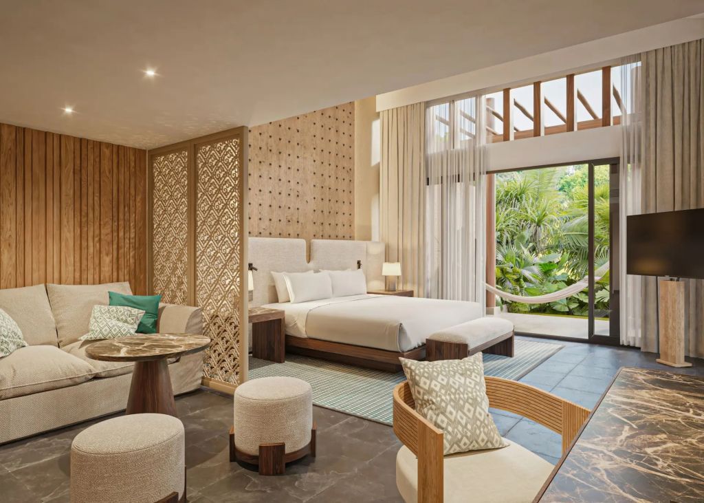 Geräumige Deluxe Villa in warmen Erdtönen mit einem Doppelbett und einer Sitzecke
