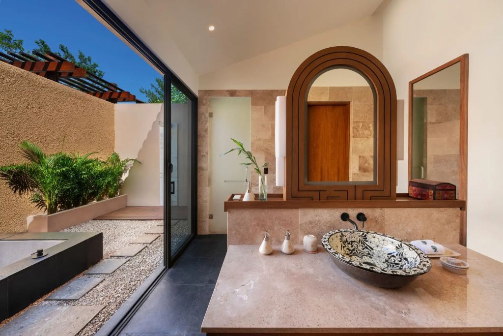 Luxus-Badezimmer mit Steinwaschbecken und Zugang zu privatem Garten
