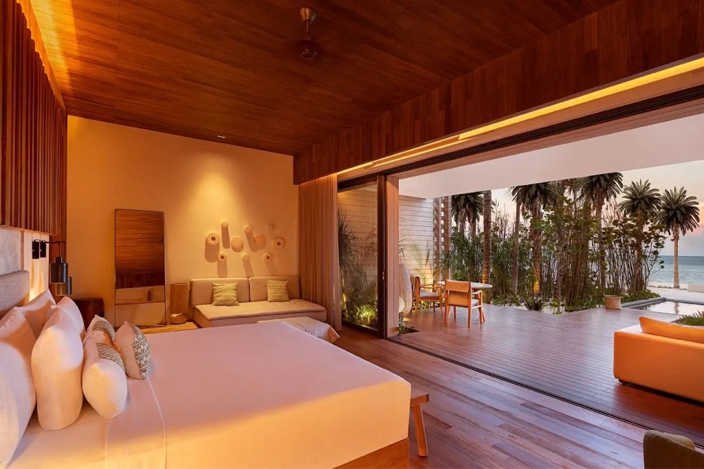 Luxuriöse Suite mit Doppelbett und gemütlicher Terrasse mit Ausblick ins Grüne