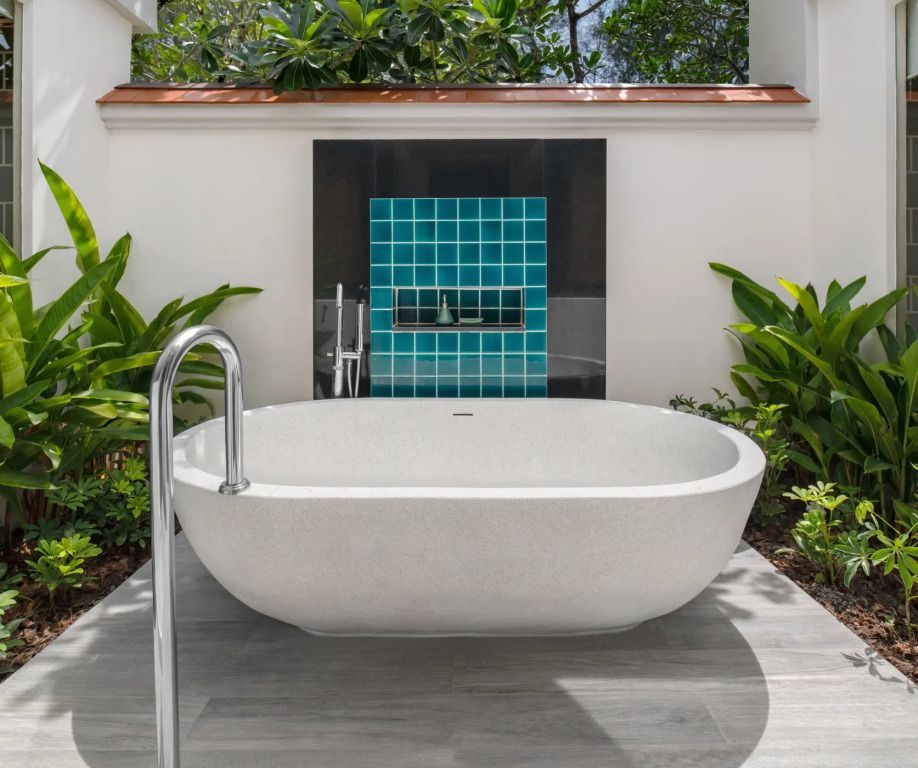Freistehende Badewanne im Freien mit grüner Umgebung und blauen Fliesen