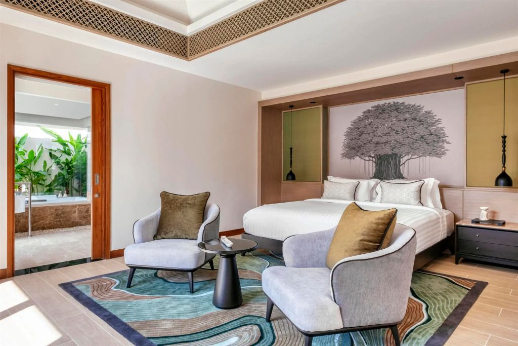 Elegantes Zimmer mit gemütlicher Sitzecke und künstlerischer Wanddekoration