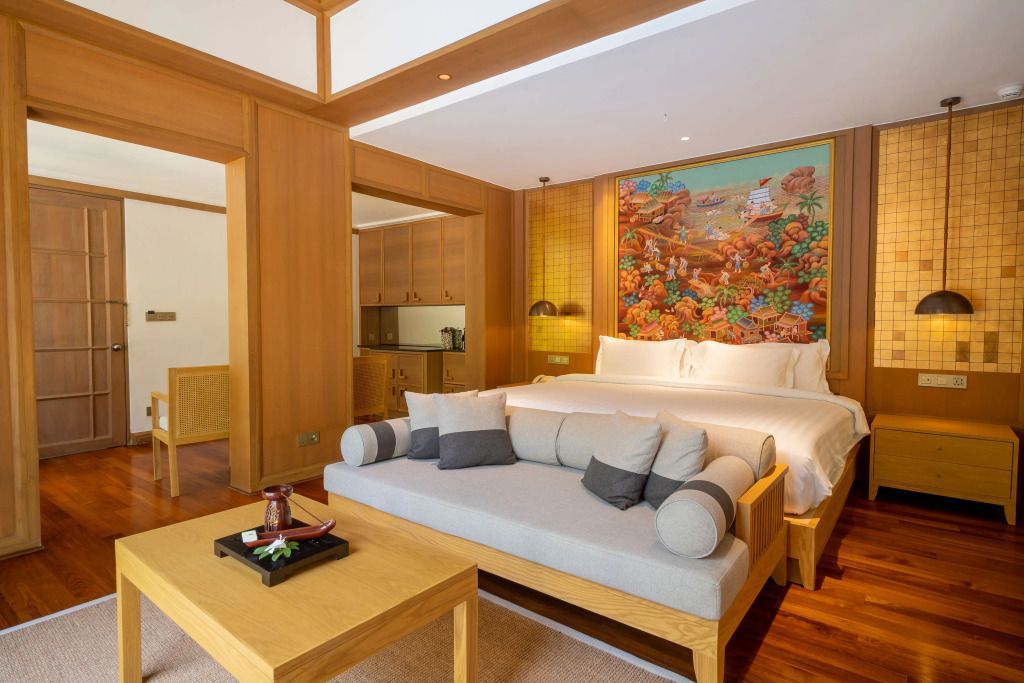 Geräumiges Schlafzimmer mit Sitzecke und künstlerischer Wanddekoration.