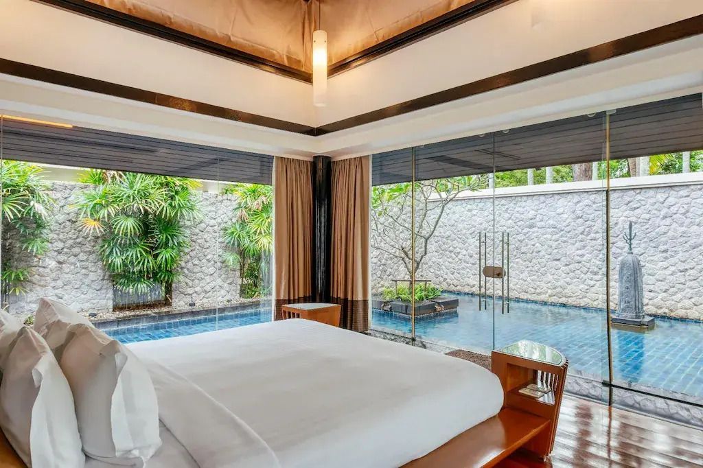 Luxuriöses Schlafzimmer mit Blick auf den privaten Pool und Garten.