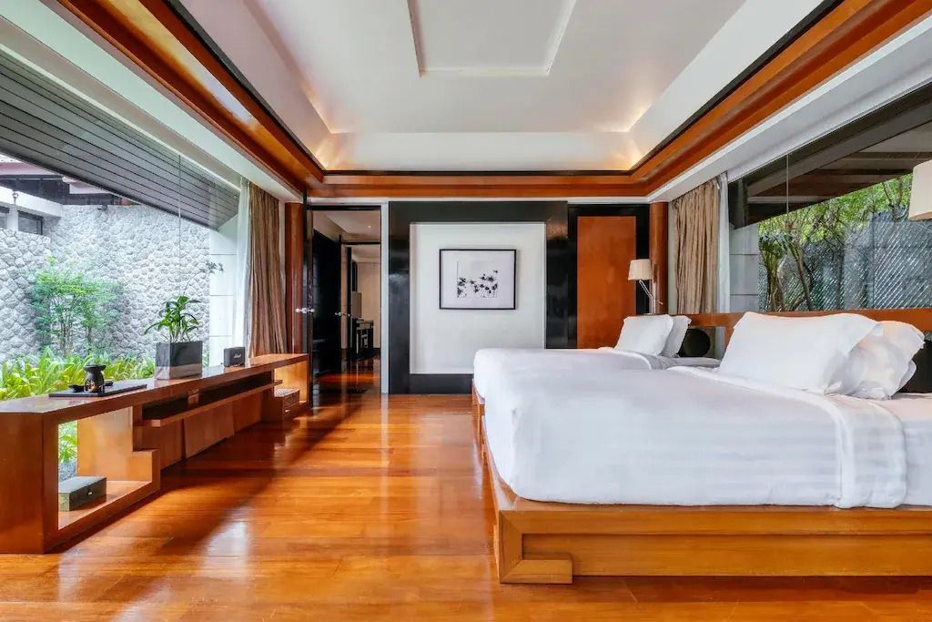 Modernes Schlafzimmer mit Holzakzenten und großen Fenstern.