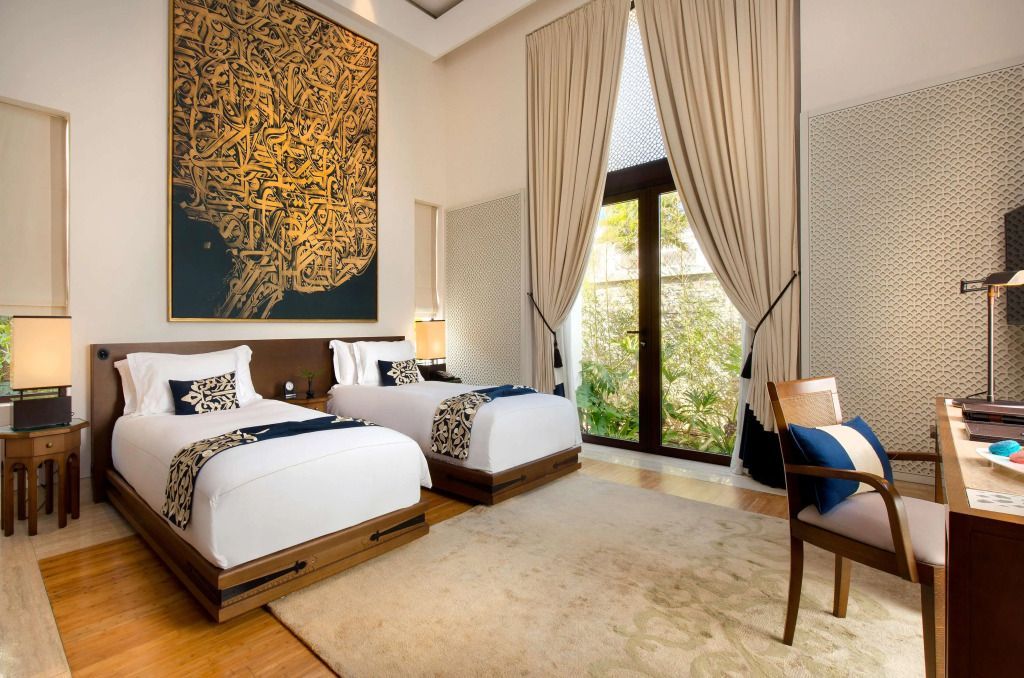 Zwei Einzelbetten in einem luxuriösen Zimmer mit großer Kunst an der Wand