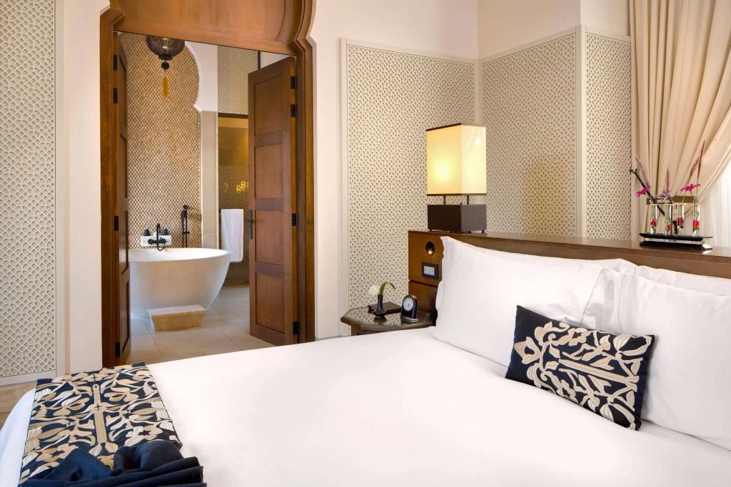 Luxuriöses Schlafzimmerdesign mit freistehender Badewanne und orientalischen Elementen.